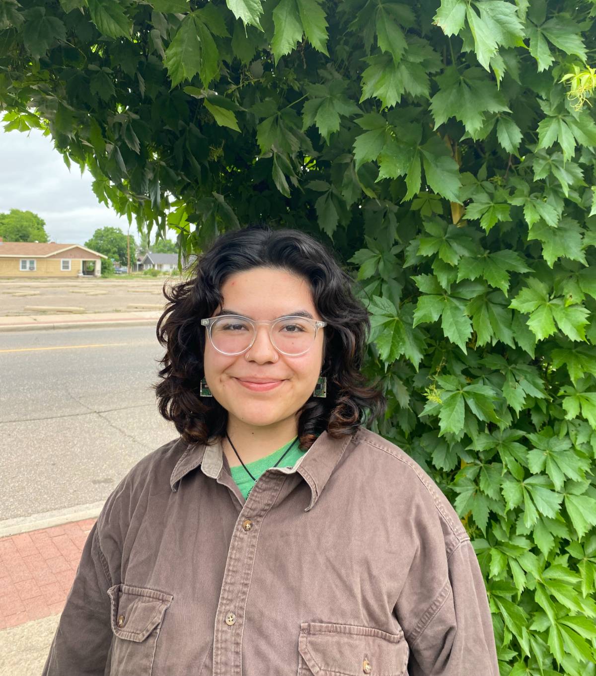Aspen Coriz-Romero in front of a leafy tree.